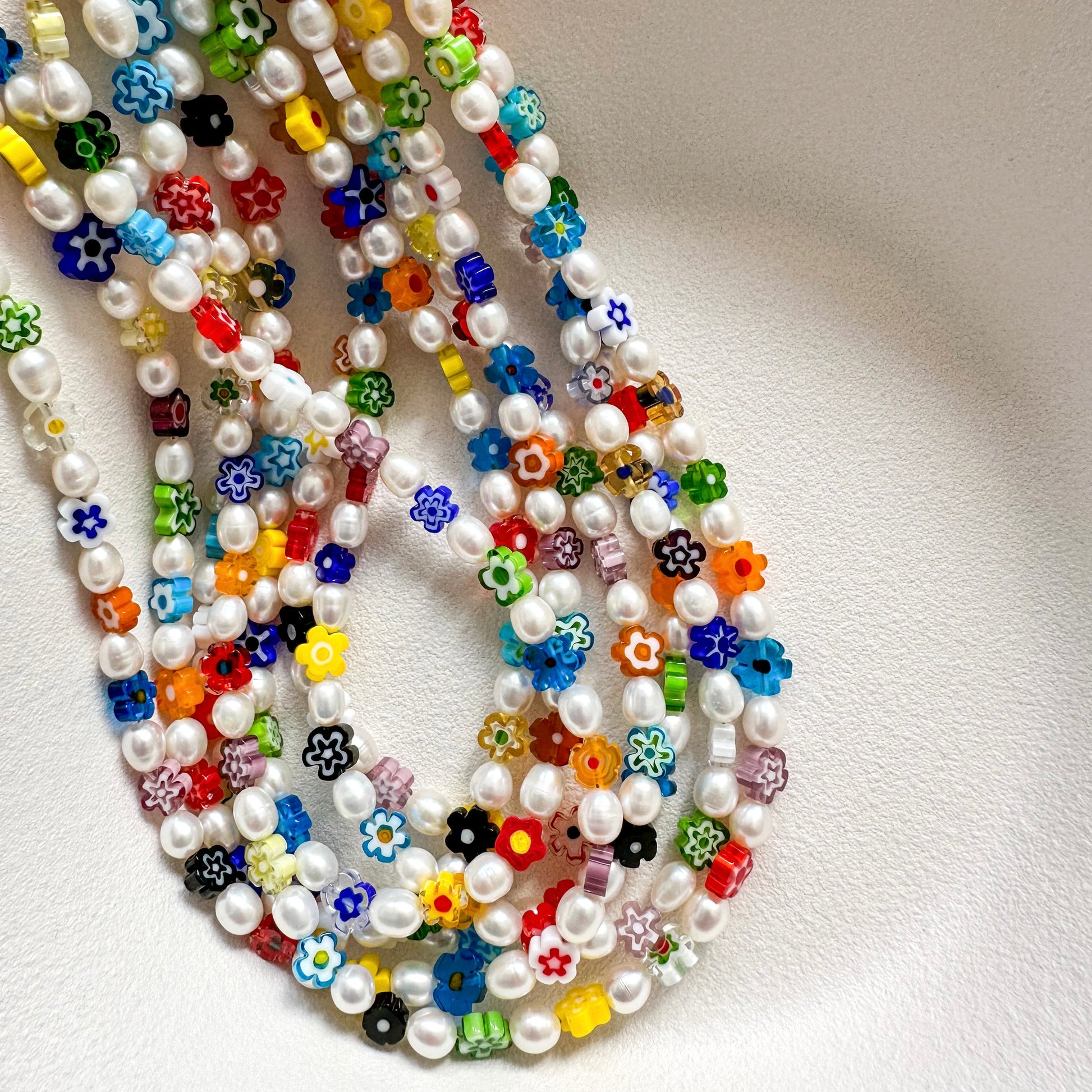 DAISY NECKLACE close-up showing vibrant millefiori glass daisy flowers and pearl details